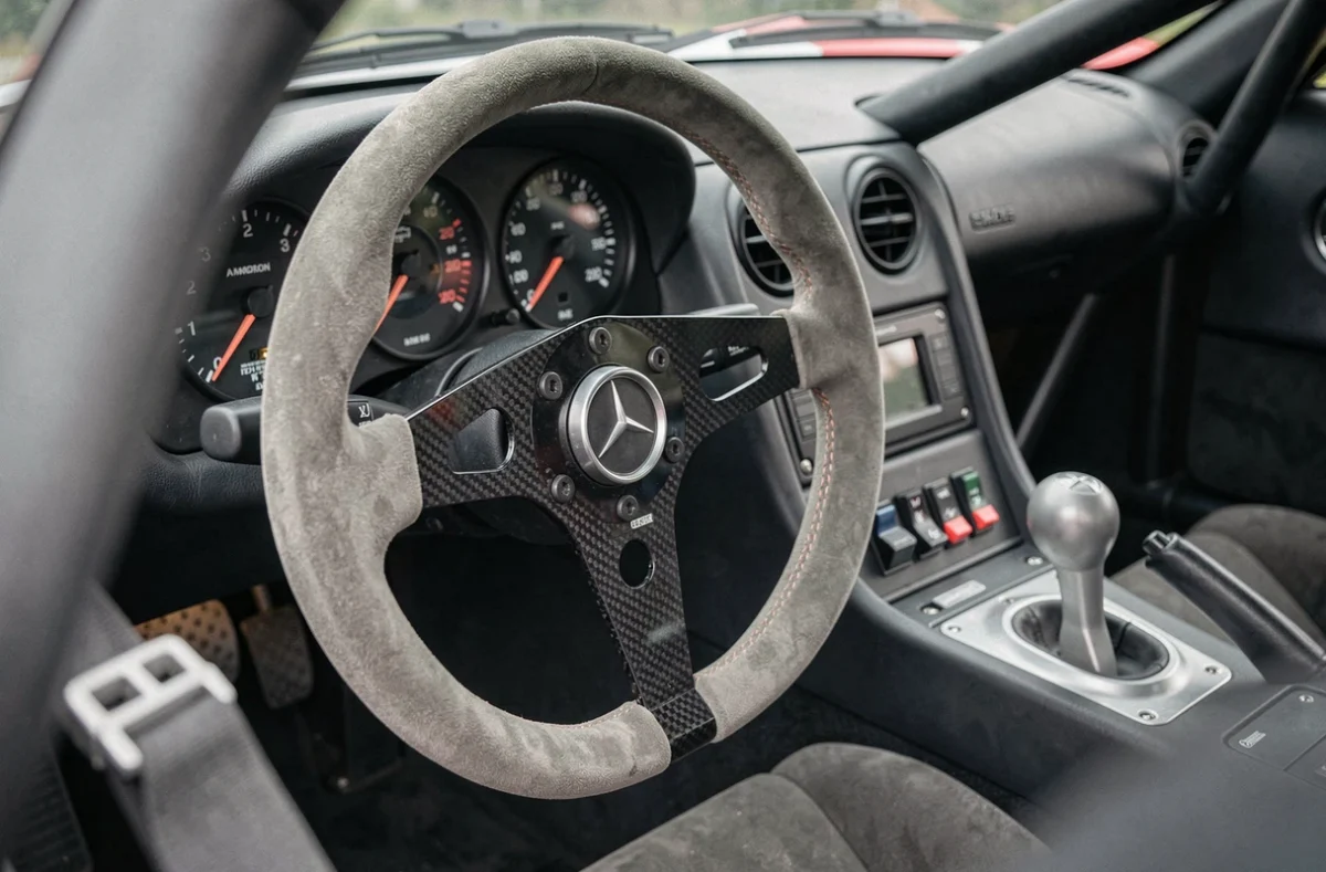 Intérieur cockpit de la Mercedes-Benz CLK GTR avec volant en daim, tableau de bord analogique et équipements de compétition d'origine